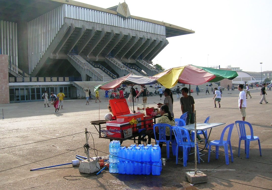 Serving cool drinks outside the beautiful sports stadium built during the 1970's under Sihanouk